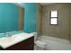 Bright bathroom features white toilet and tub with blue accent wall and dark wood vanity at 16 Water Trak, Ocala, FL 34472