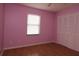 Bedroom with pink walls, laminated floors, large window, and double sliding door closet at 16 Water Trak, Ocala, FL 34472