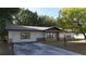 Single-story home with stone accents, a driveway, and mature trees at 16 Water Trak, Ocala, FL 34472