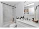Bright bathroom featuring a tub with shower, white vanity, and decorative mirror at 16848 Sw 41St Avenue Rd, Ocala, FL 34473