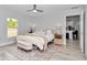 Bright bedroom features a ceiling fan, ensuite access, bench, and a decorative rug at 16848 Sw 41St Avenue Rd, Ocala, FL 34473