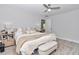 Bright bedroom features a ceiling fan, ensuite access, bench, and a decorative rug at 16848 Sw 41St Avenue Rd, Ocala, FL 34473