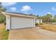 Exterior view of home with a two-car garage, and simple landscaping and fresh concrete driveway at 16848 Sw 41St Avenue Rd, Ocala, FL 34473