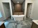 Elegant bathroom with freestanding tub, gray tile floors, wood accent wall, and modern fixtures at 18890 Sw 60Th St, Dunnellon, FL 34432
