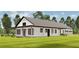 Newly constructed home with covered porch, green lawn, and beautiful trees at 18890 Sw 60Th St, Dunnellon, FL 34432