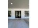 Exterior shot of a front door with black trim, flanked by windows and covered entry at 18890 Sw 60Th St, Dunnellon, FL 34432