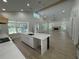 Bright, open-concept living room with a fireplace, wood-look floors, and an island bar overlooking the yard at 18890 Sw 60Th St, Dunnellon, FL 34432
