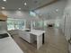 Open-concept living room featuring wood-look tile floors, a fireplace, large windows, and an island bar at 18890 Sw 60Th St, Dunnellon, FL 34432