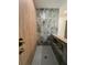 Modern walk-in shower featuring gray penny tile floors, wood accent wall, and large-format marbled tile wall at 18890 Sw 60Th St, Dunnellon, FL 34432
