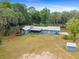 Aerial view of property featuring the home, storage shed, and large yard at 19300 Sw 60Th St, Dunnellon, FL 34432