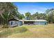Back exterior of home features a deck, a screened in porch, and a chimney at 19300 Sw 60Th St, Dunnellon, FL 34432