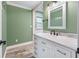 Bright bathroom with white marble vanity, modern fixtures, and a green painted wall at 19300 Sw 60Th St, Dunnellon, FL 34432