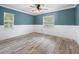 Cozy bedroom with wainscoting, neutral-toned walls, ceiling fan, and two large windows at 19300 Sw 60Th St, Dunnellon, FL 34432