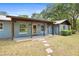Inviting single-story home featuring a covered porch, stone walkway, and well-maintained landscaping at 19300 Sw 60Th St, Dunnellon, FL 34432