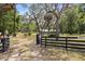 Gated entrance leading to a charming home surrounded by mature trees, providing privacy and curb appeal at 19300 Sw 60Th St, Dunnellon, FL 34432