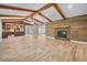 Open-concept living room featuring a modern fireplace, wood-look tile flooring, and easy access to the kitchen at 19300 Sw 60Th St, Dunnellon, FL 34432
