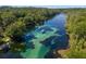 Beautiful aerial view of the river with boats, clear waters, and lush trees, highlighting recreational opportunities at 19395 Sw 100Th Loop, Dunnellon, FL 34432