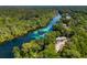Expansive aerial view of river, homes, and clear waters surrounded by a dense forest, showcasing a serene escape at 19395 Sw 100Th Loop, Dunnellon, FL 34432