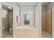 Well-lit bathroom featuring a soaking tub, separate shower, and floral accents at 19395 Sw 100Th Loop, Dunnellon, FL 34432