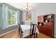 Cozy dining area boasts a large window, chandelier, and classic wood furniture at 19395 Sw 100Th Loop, Dunnellon, FL 34432