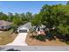 Well-maintained home with a spacious driveway, mature trees, and attractive landscaping at 19395 Sw 100Th Loop, Dunnellon, FL 34432
