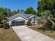 Beautiful home with a long driveway, lush landscaping, and a two-car garage at 19395 Sw 100Th Loop, Dunnellon, FL 34432