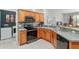Well-equipped kitchen with sleek black appliances, tile backsplash, and wooden cabinets at 19395 Sw 100Th Loop, Dunnellon, FL 34432