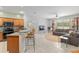 Open-concept kitchen and living area with breakfast bar, black appliances, and a cozy sitting area at 19395 Sw 100Th Loop, Dunnellon, FL 34432