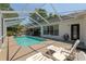 Screened-in pool area featuring lounge chairs, a sparkling pool, and access to the home at 19395 Sw 100Th Loop, Dunnellon, FL 34432