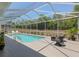 Beautiful screened-in pool with lounge chairs and landscaping offering a serene backyard oasis at 19395 Sw 100Th Loop, Dunnellon, FL 34432