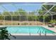 Sparkling in-ground pool surrounded by a screened enclosure and lush greenery for privacy at 19395 Sw 100Th Loop, Dunnellon, FL 34432