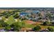 Aerial shot showcases a neighborhood with homes adjacent to a scenic golf course and a calm lake at 2008 Palo Alto Ave, The Villages, FL 32159