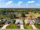 An aerial view of homes on a golf course showcasing mature landscaping under a partly cloudy blue sky at 2008 Palo Alto Ave, The Villages, FL 32159