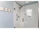 Modern bathroom featuring a sleek glass shower with grab bars and white tile surround, complemented by blue accents at 2008 Palo Alto Ave, The Villages, FL 32159