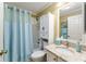 Bathroom featuring a shower with a blue curtain, vanity with granite countertop, and built in shelving above the toilet at 2008 Palo Alto Ave, The Villages, FL 32159