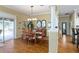 Bright dining room with hardwood floors, chandelier lighting, and sliding door leading to the outdoor patio at 2008 Palo Alto Ave, The Villages, FL 32159