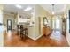 Inviting entryway featuring hardwood floors, decorative mirror, and views into the adjacent kitchen with breakfast bar at 2008 Palo Alto Ave, The Villages, FL 32159