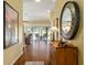 An inviting entryway featuring a decorative mirror, wooden floors, and a view of the pool area at 2008 Palo Alto Ave, The Villages, FL 32159
