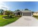 Landscaped home featuring a decorative driveway, a two-car garage, and mature palm trees at 2008 Palo Alto Ave, The Villages, FL 32159