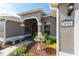Inviting front entrance with a red leaded glass door, custom fountain, and vibrant landscaping at 2008 Palo Alto Ave, The Villages, FL 32159