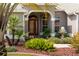 Inviting front entrance with lush landscaping, decorative fountain, and a red front door at 2008 Palo Alto Ave, The Villages, FL 32159