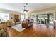 Comfortable living room with hardwood floors, ceiling fan, and sliding glass doors to the patio at 2008 Palo Alto Ave, The Villages, FL 32159