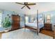 Spacious main bedroom with a four-poster bed, ceiling fan, and a colorful area rug at 2008 Palo Alto Ave, The Villages, FL 32159