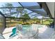 Tranquil pool with screened enclosure, featuring a cozy seating area for enjoying the beautiful landscaped surroundings at 2008 Palo Alto Ave, The Villages, FL 32159