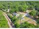 An aerial view captures a house with a new roof, a lush green yard, and a train track nestled among verdant trees at 2376 Se 40Th Street Road, Ocala, FL 34480