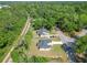 Aerial view of a home with a manicured lawn and a long driveway surrounded by lush trees and a train track nearby at 2376 Se 40Th Street Road, Ocala, FL 34480
