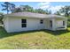 View of the rear exterior and covered patio of the home and the green lawn at 2376 Se 40Th Street Road, Ocala, FL 34480