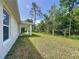 View of the expansive backyard, featuring a covered patio and lush green lawn perfect for outdoor activities at 2376 Se 40Th Street Road, Ocala, FL 34480