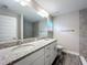 Bright bathroom featuring double vanity with granite countertops, modern fixtures, and a tiled shower at 2376 Se 40Th Street Road, Ocala, FL 34480