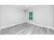 Bright bedroom featuring a ceiling fan, gray wood-look floors, and a large window allowing natural light at 2376 Se 40Th Street Road, Ocala, FL 34480